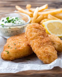 Assiette avec poisson pané au Air Fryer, croustillant et doré. Servi avec frites, rondelle de citron et sauce tartare aux herbes fraîches.