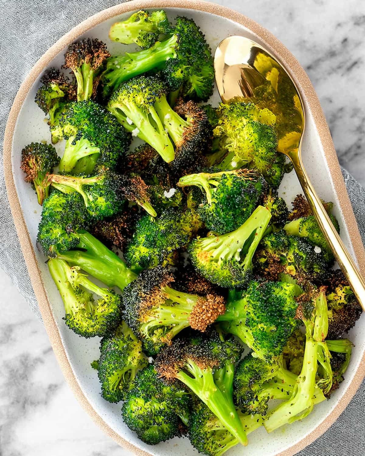 Assiette de brocolis surgelés au Air Fryer, bien dorés sur les bords.