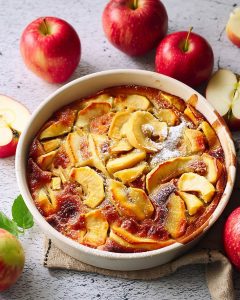Clafoutis pommes au Air Fryer dans un plat rond. Les pommes sont dorées et fondantes.
