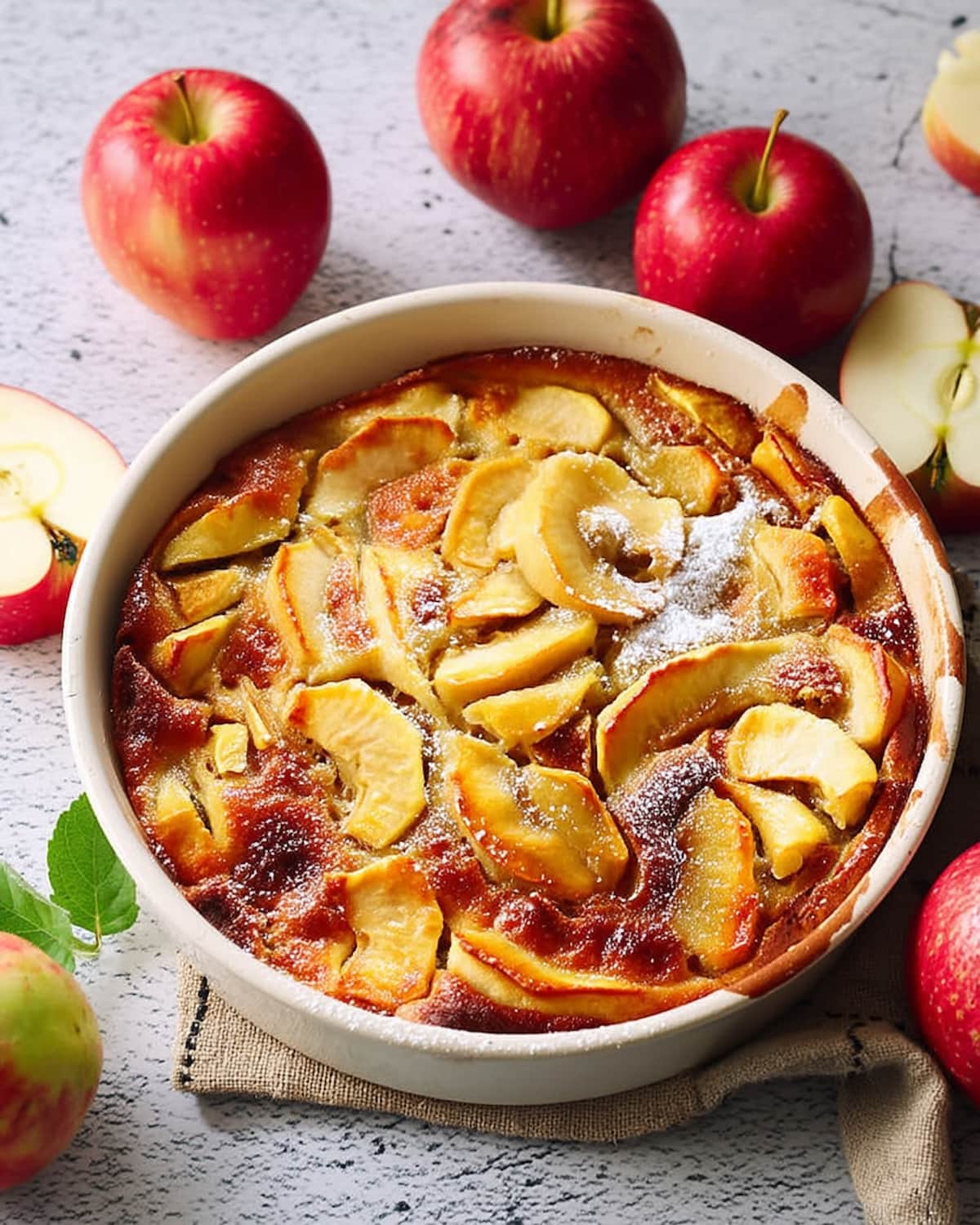 Clafoutis pommes au Air Fryer dans un plat rond. Les pommes sont dorées et fondantes.