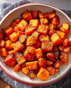 Cubes de butternut au Air Fryer, bien dorés et croustillants, saupoudrés d’herbes.