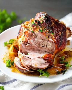 Cuisse de dinde épicée au Air Fryer, dorée, tranchée sur assiette blanche.