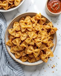 Bol de chips de pâtes à l’airfryer croustillantes au parmesan, bien dorées, prêtes pour l’apéro