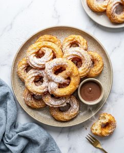 Oreillettes au airfryer dorées et croustillantes, saupoudrées de sucre glace, servies sur une assiette
