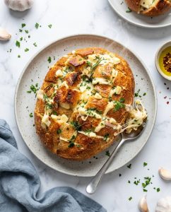 Pain à l’ail air fryer express au fromage, croûte dorée et mozzarella filante, servi en tranches sur une planche
