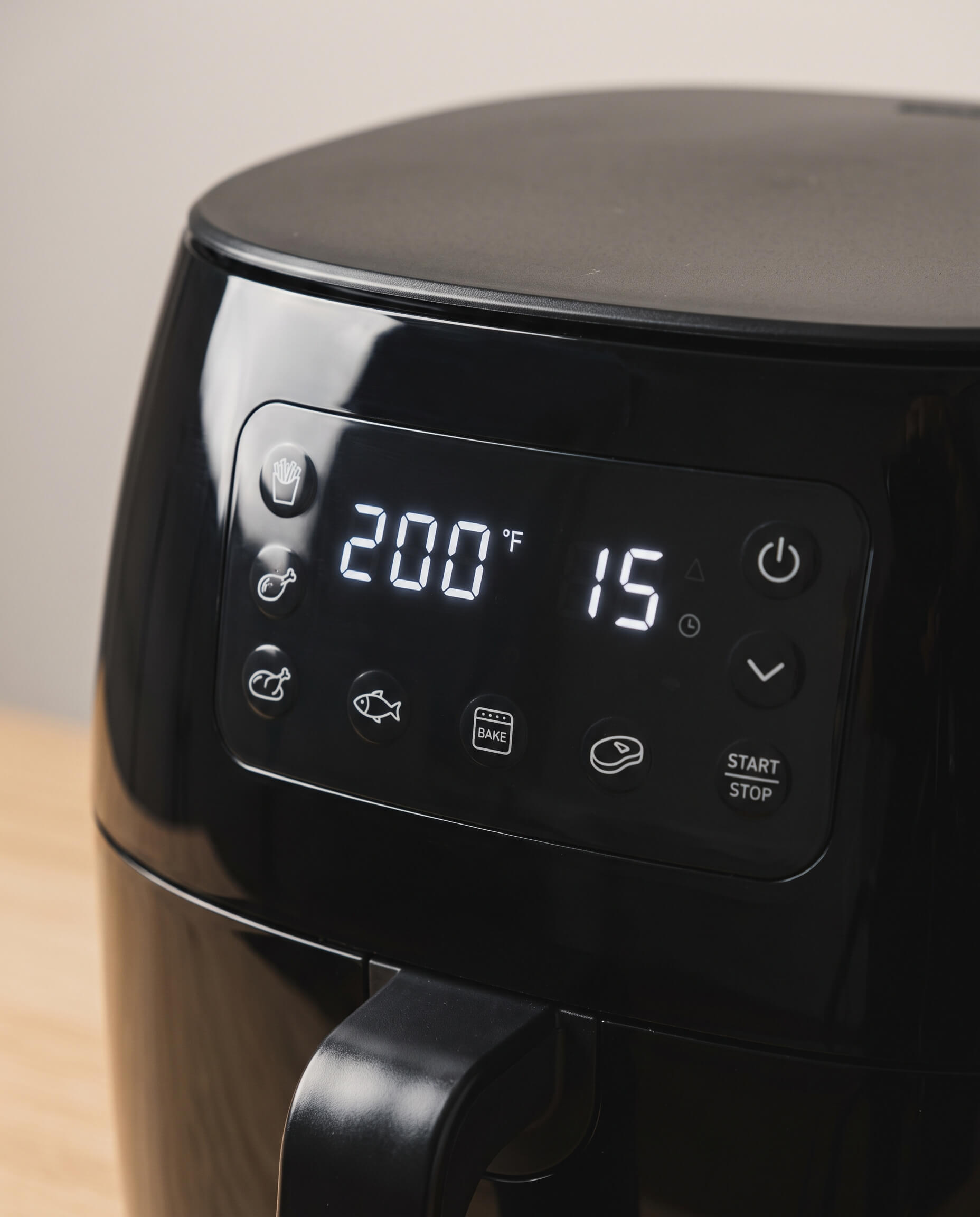 Écran d'un air fryer affichant la température et la durée au milieu des touches de préréglage