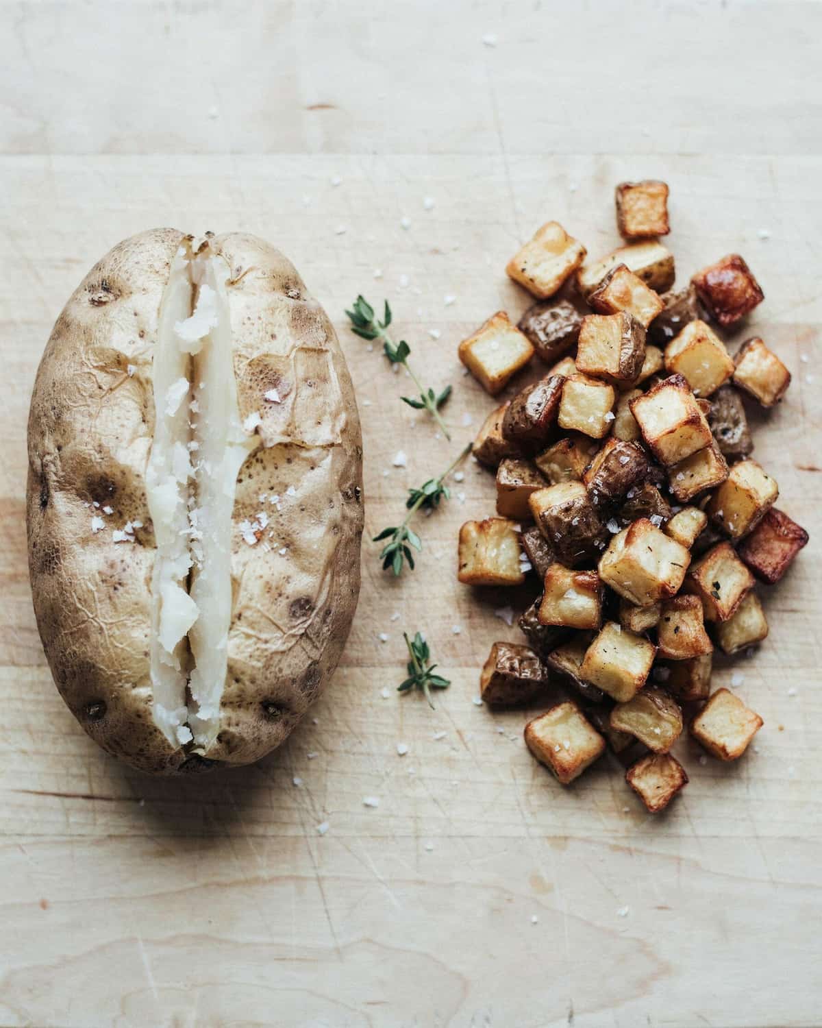 Pomme de terre entière et pommes de terre en cubes cuites au air fryer, posées côte à côte