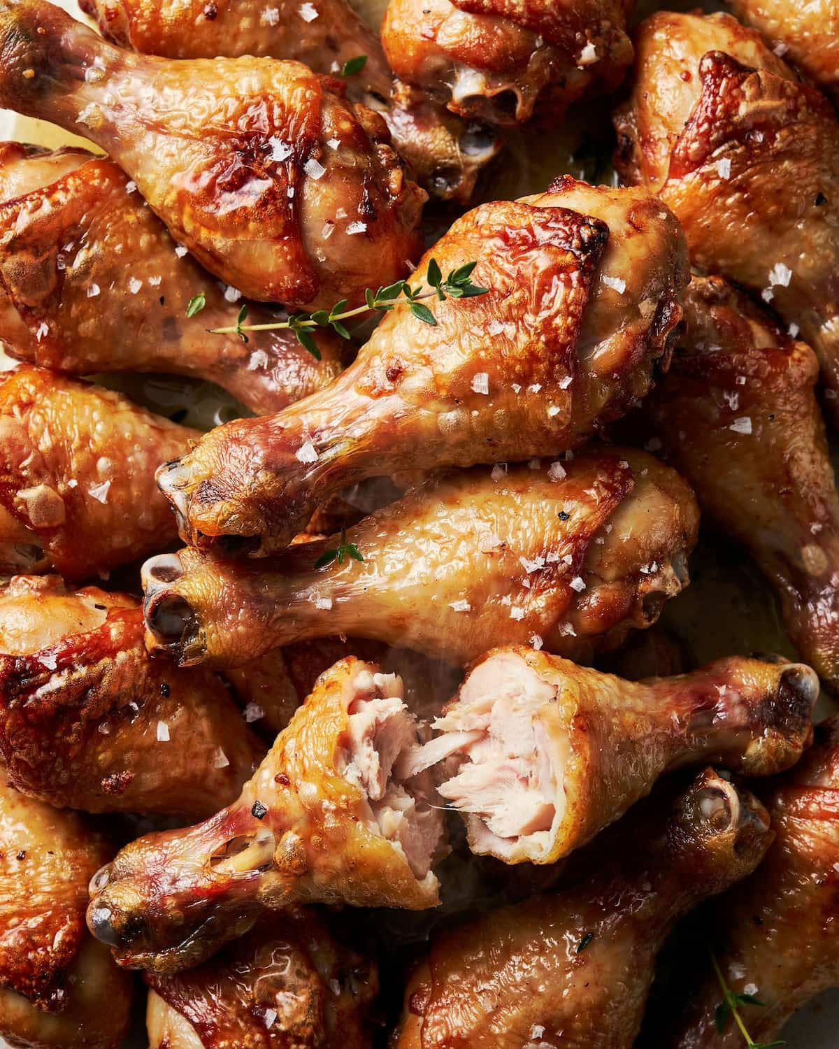 Pilons de poulet dorés cuits au air fryer, l'un ouvert montrant la chair à cœur