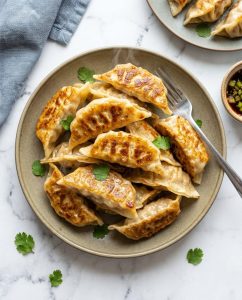Gyozas au airfryer croustillants servis chauds avec sauce soja-gingembre, dorés et bien scellés