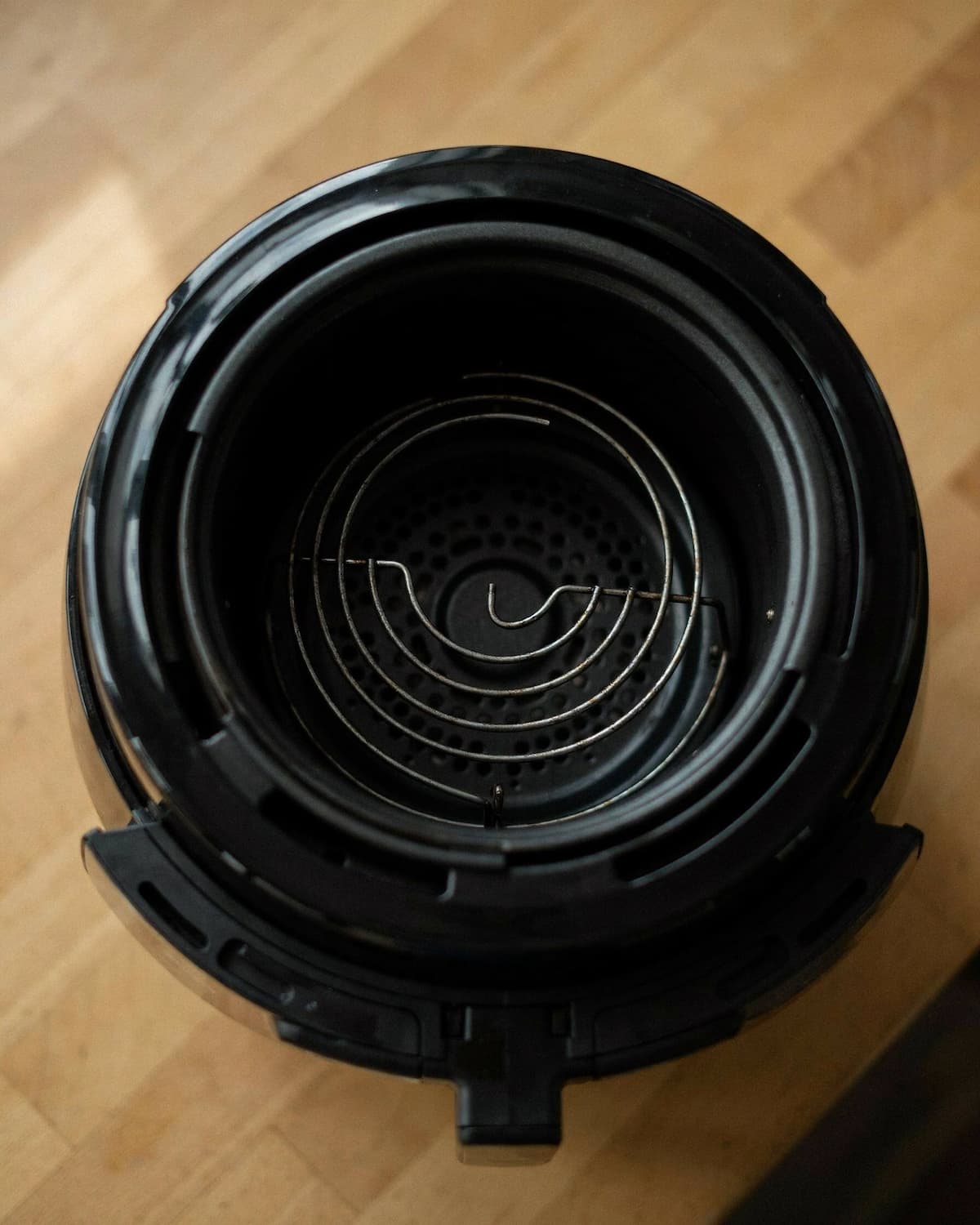Intérieur d’un air fryer panier retiré, résistance en spirale et grille du ventilateur visibles
